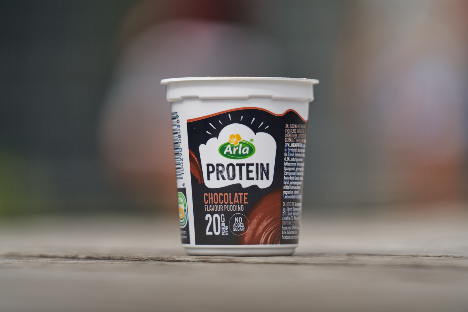 Kobieta w czerwonej bluzce jedząca pudding drewnianą łyżką